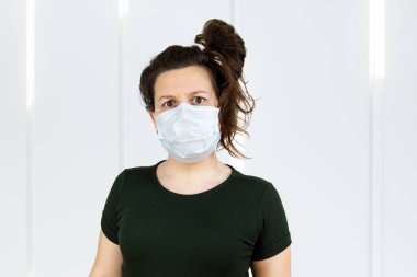 Kadın evde koruyucu yüz maskesi takıyor grip virüsüne karşı koruma virüs salgınlarını önlüyor, izole ediliyor..