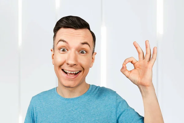 Joven Chico Sonriente Vestido Con Una Camiseta Azul Mostrar Signo —  Fotos de Stock