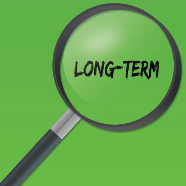 Uzun vadeli metin yeşil zemin üzerine bir büyüteç altında.