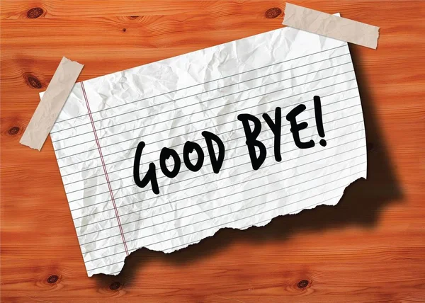 GOOD BYE   handwritten on torn notebook page crumpled paper on wood texture background.
