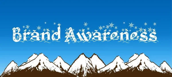 BRAND AWARENESS written with snowflakes on blue sky and snowy mountains background.