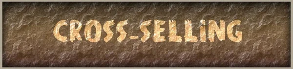 CROSS SELLING written with paint on rock panel background