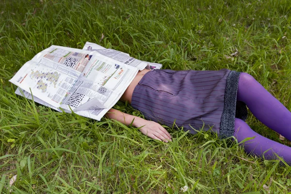 Молода жінка лежить на траві — стокове фото