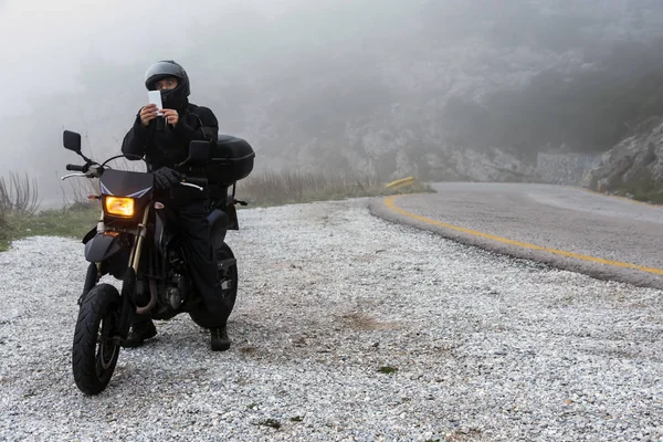 Jinete está tratando de encontrar la señal en su móvil en un día de niebla — Foto de Stock