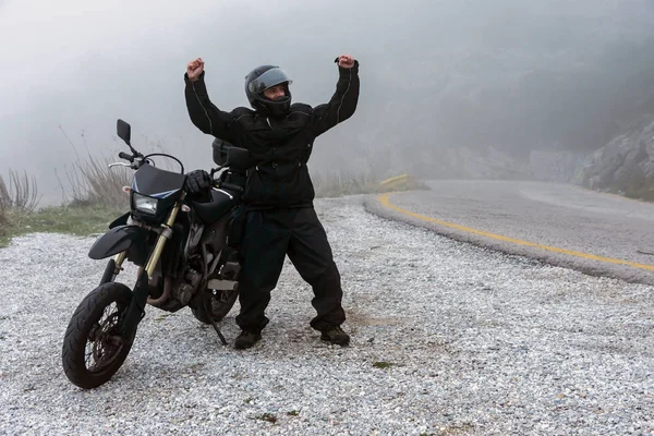 Cavaleiro comemorar seu passeio de sucesso em um dia nebuloso na montanha Fotos De Bancos De Imagens