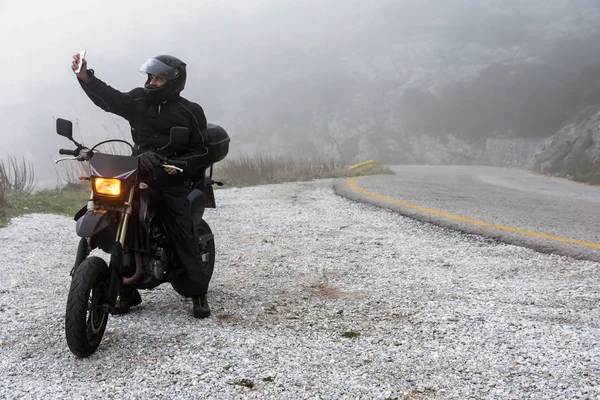 Jinete está tratando de encontrar la señal en su móvil en un día de niebla — Foto de Stock