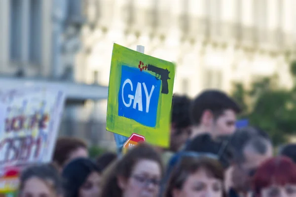 Foto turva da multidão marchando enquanto segurava um tablet 'gay' em — Fotografia de Stock