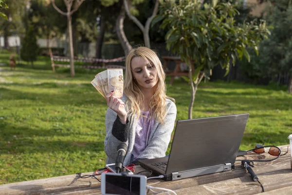 Жіночий Блогер Демонструє Гроші Отримані Від Інтернет Послуг Працюючи Відкритому — стокове фото