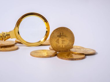 Altın Bitcoin kopyası ve beyaz sırtüstü büyüteç