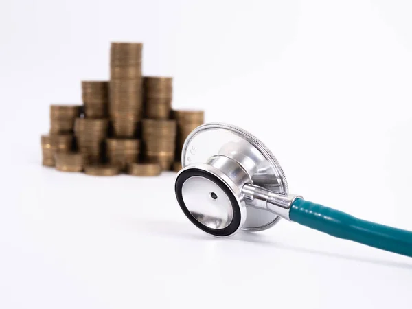 Estetoscopio sobre pila de monedas, sobre fondo blanco. dinero para la salud — Foto de Stock