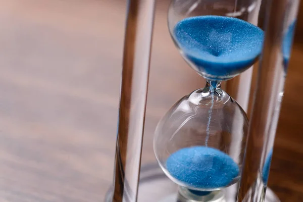 Classic hourglass with blue sand pouring — Stock Photo, Image