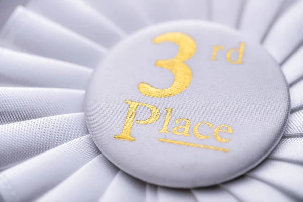 Third place winners white rosette with gold text — Stock Photo, Image
