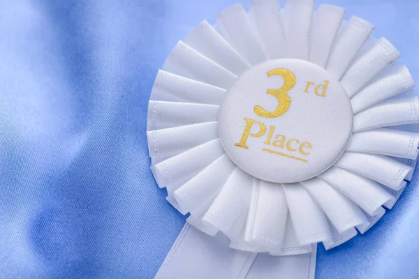 Third place winners white rosette with gold text — Stock Photo, Image