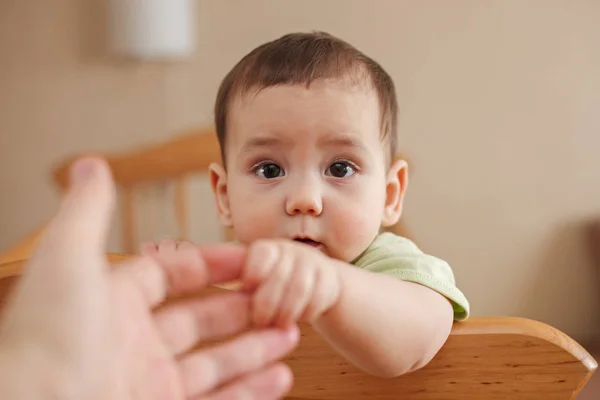 Cute baby boy holding his mothers finger — Stock Photo, Image