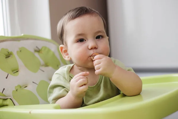 Thoughtful little baby boy eating — Stock Photo, Image