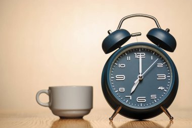 Masada kahve fincanı olan çalar saat.