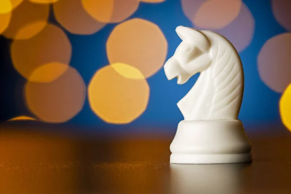 White horse chess piece over a colorful bokeh — ストック写真