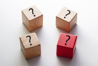 Soru işaretleriyle süslenmiş dört tahta blok.