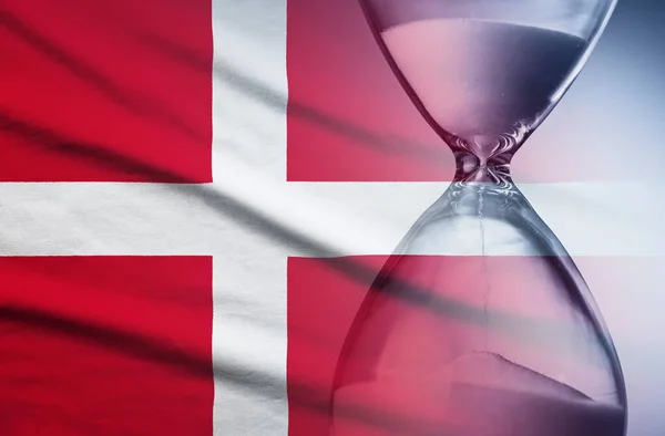 Yetiştirme tarihlerinin üst üste eklenmiş kum saati kavramına sahip Danimarka bayrağı — Stok fotoğraf