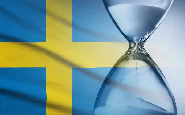 Hourglass over the flag of the Sweden — Stok fotoğraf