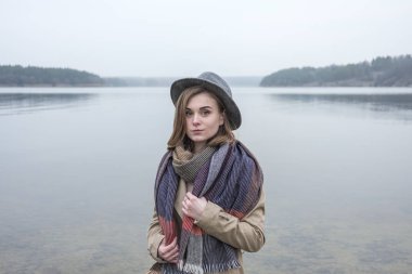 Stylish young woman outdoors in winter on a cold misty day