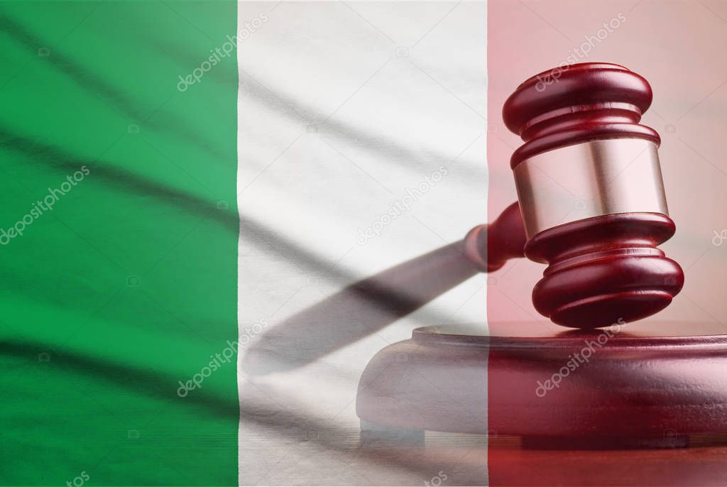 Legal gavel over a flag of the Italy