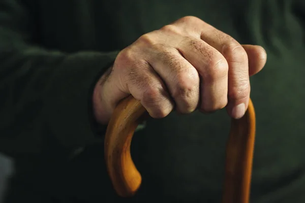 Karanlıkta vurgulanmış yaşlı bir adamın eli — Stok fotoğraf