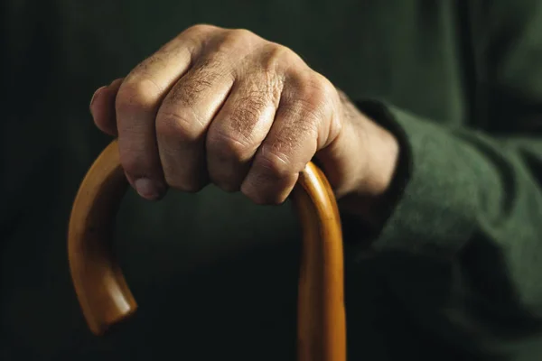 Mano de un anciano sosteniendo un bastón — Foto de Stock