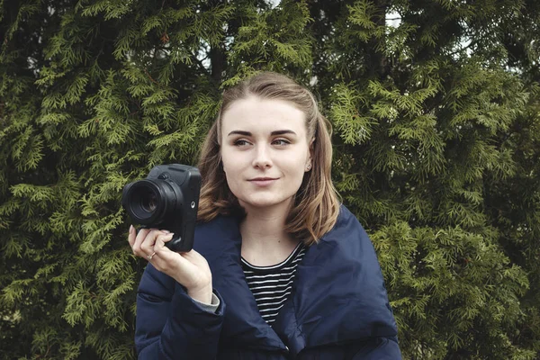Attraktiv leende fotograf håller sin kamera i en hand — Stockfoto