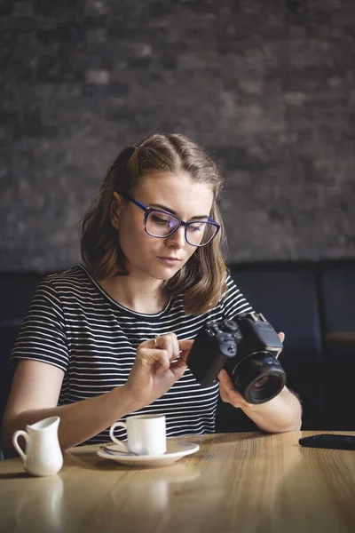 Mujer joven fotografiando chillando sus fotos mientras se sienta relajada — Foto de Stock