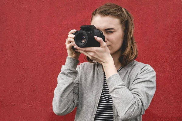 Genç bayan fotoğrafçı izleyiciye odaklanıyor.