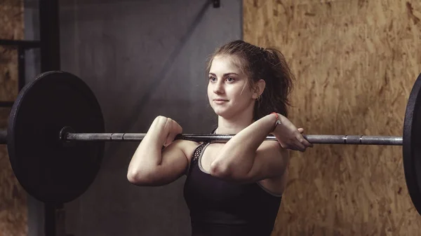 Strong muscular woman working out with a barbell — Stock Photo, Image