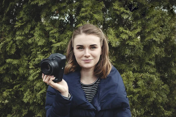 Attraktiv leende fotograf håller sin kamera — Stockfoto