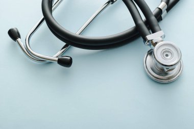 Yukarıdan sarmalanmış steteskop, tıbbi, sağlık, kardiyoloji veya Covid-19 konseptinde telif alanı olan beyaz bir stüdyonun arka planında