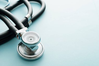 Tıbbi tedavi ve teşhis, kardiyoloji ya da koronavirüs ya da Covid-19 salgını konsepti üzerine odaklanmış mavi bir stüdyonun arka planındaki stetoskopu kapat.