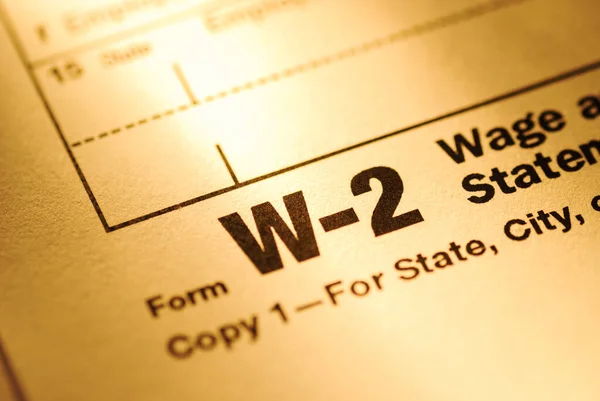 Close up on a Form W-2 Wage and Tax statement form for the US Treasury or IRS with focus to the title in yellow light