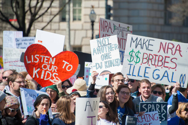 Participants in the March for Our Lives, a protest by students for gun control, hold signs on March 24, 2018 in Washington DC  