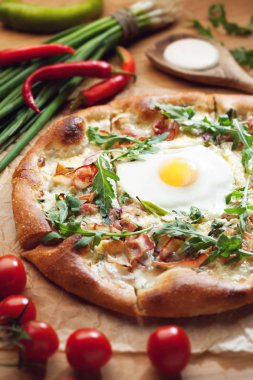 Ahşap masa üzerinde malzemelerle taze pizza