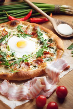 Ahşap masa üzerinde malzemelerle taze pizza