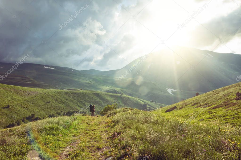 Hiker with a backpack walking through mountain valley