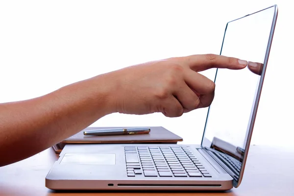 Hand and finger touch screen on monitor a laptop on a wooden table — Stock Photo, Image