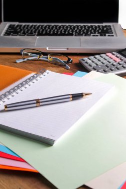 Ofis işyeri dizüstü bilgisayar ve tahta masalarda akıllı telefon