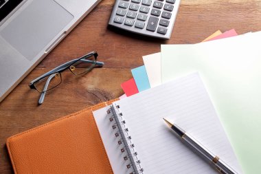 Ofis işyeri dizüstü bilgisayar ve tahta masalarda akıllı telefon