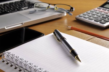 Ofis işyeri dizüstü bilgisayar ve tahta masalarda akıllı telefon