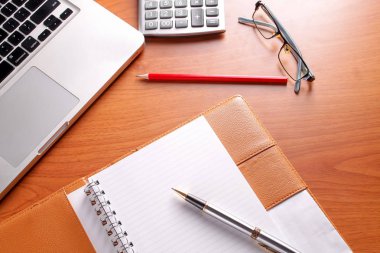 Ofis işyeri dizüstü bilgisayar ve tahta masalarda akıllı telefon