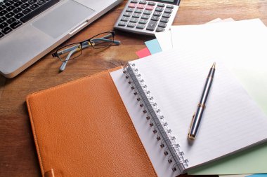 Ofis işyeri dizüstü bilgisayar ve tahta masalarda akıllı telefon