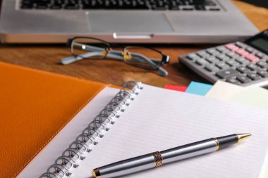 Ofis işyeri dizüstü bilgisayar ve tahta masalarda akıllı telefon