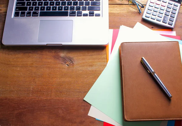 Ofis işyeri dizüstü bilgisayar ve tahta masalarda akıllı telefon