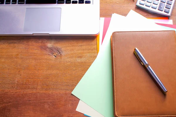 Ofis işyeri dizüstü bilgisayar ve tahta masalarda akıllı telefon