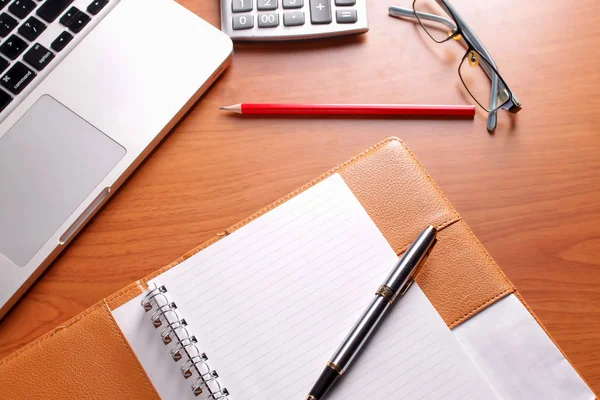 Ofis işyeri dizüstü bilgisayar ve tahta masalarda akıllı telefon